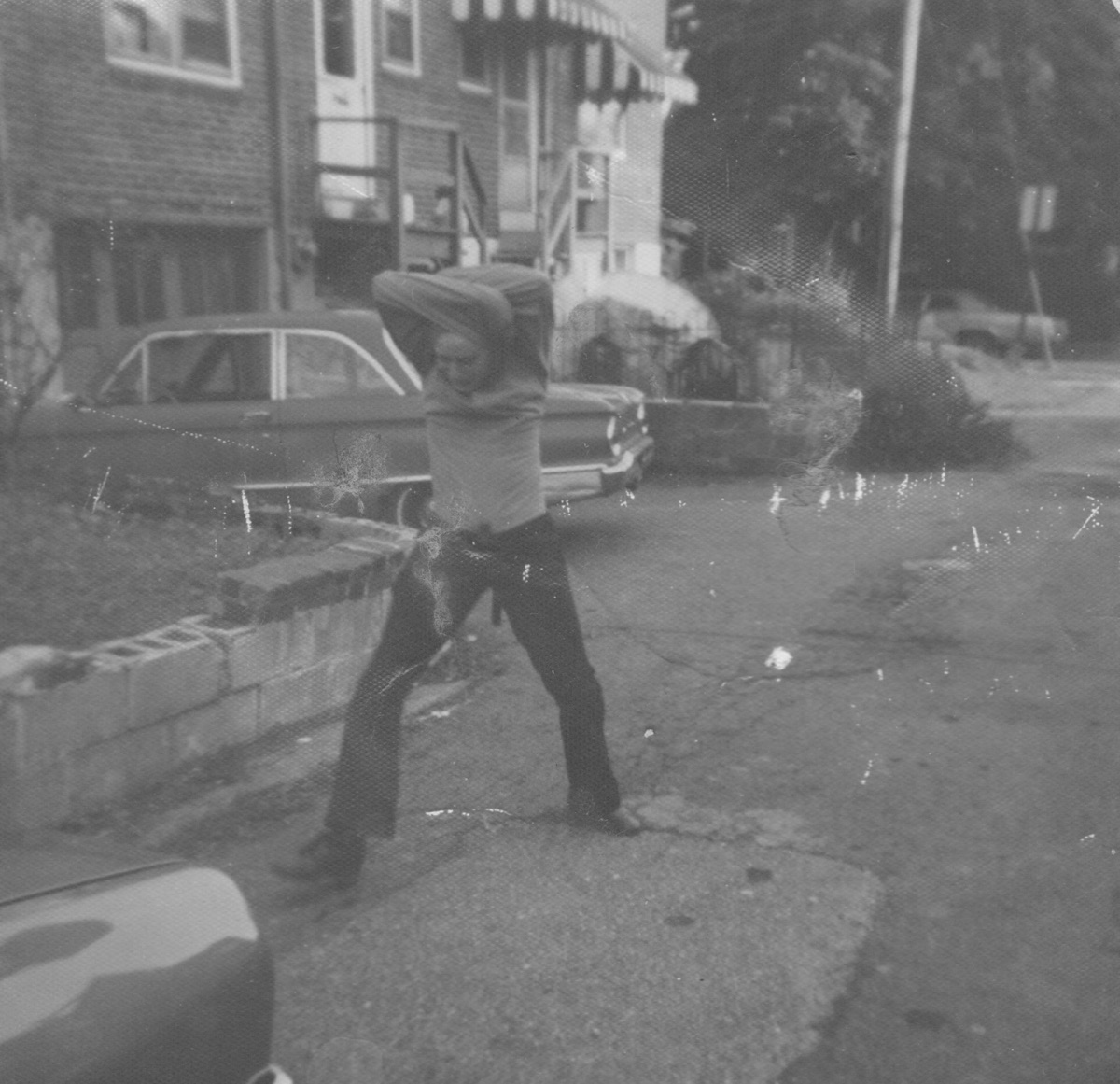 Wearing the straitjacket I built, about age fourteen. The damage is the photograph's own.